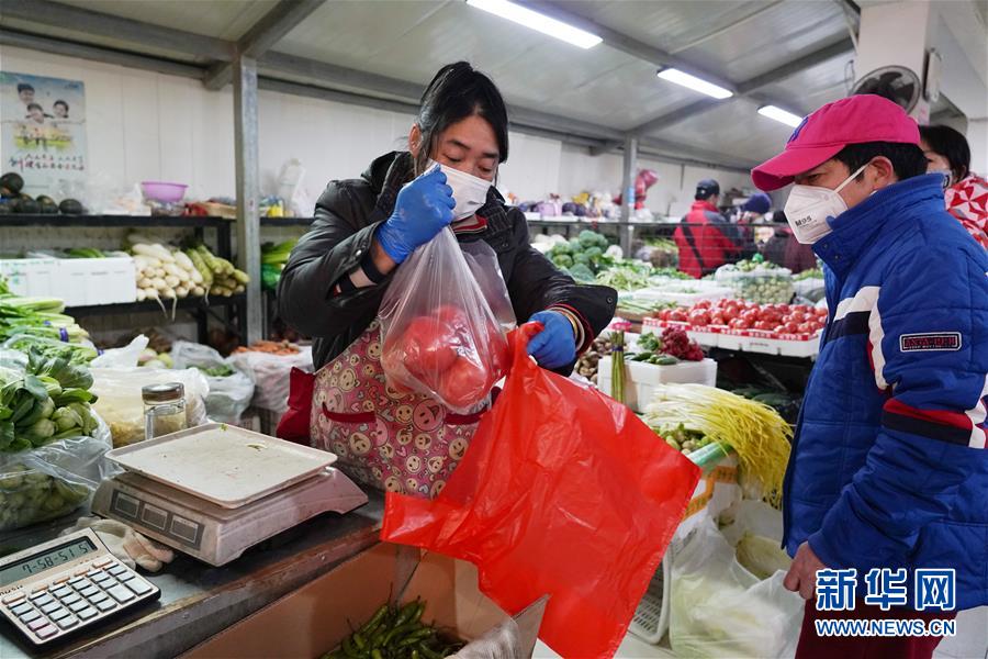 베이징시 둥청구 자오다오커거리 푸샹 지역사회, 마스크를 쓴 채소가게 주인이 손님에게 채소를 담아주고 있다. [2월 12일 촬영/사진 출처: 신화망]