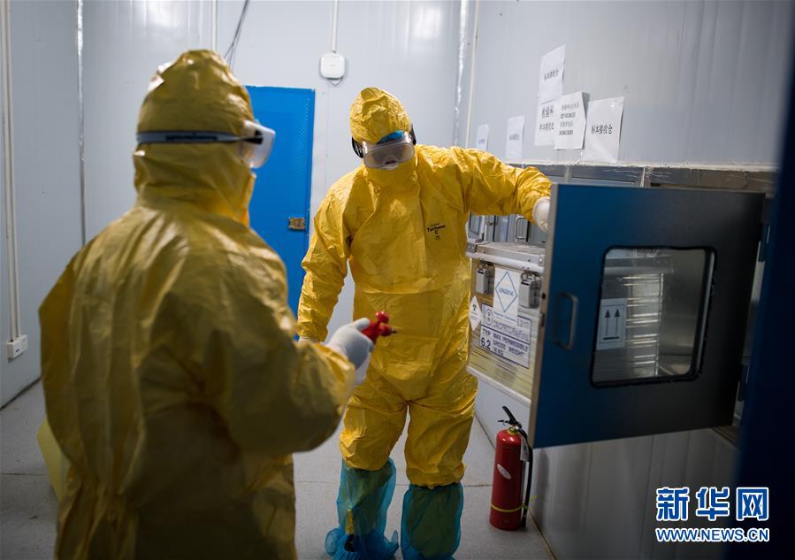 류썬보(오른쪽)와 동료 메이이치가 바이러스 샘플을 상자에서 꺼내고 있다. [2월 24일 촬영/사진 출처: 신화망]