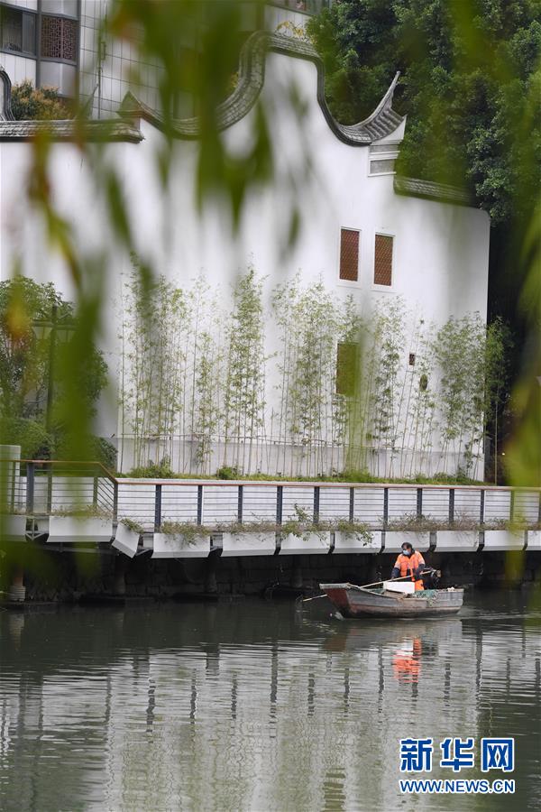 환경 미화원이 푸저우 진안허공원의 고조 근처 물 표면을 청소하고 있다. 푸저우 진안허공원은 양안의 고조 고택을 보존한 채로 민파 모조 건축물을 새로 지었다. [3월 6일 촬영/사진 출처: 신화망]