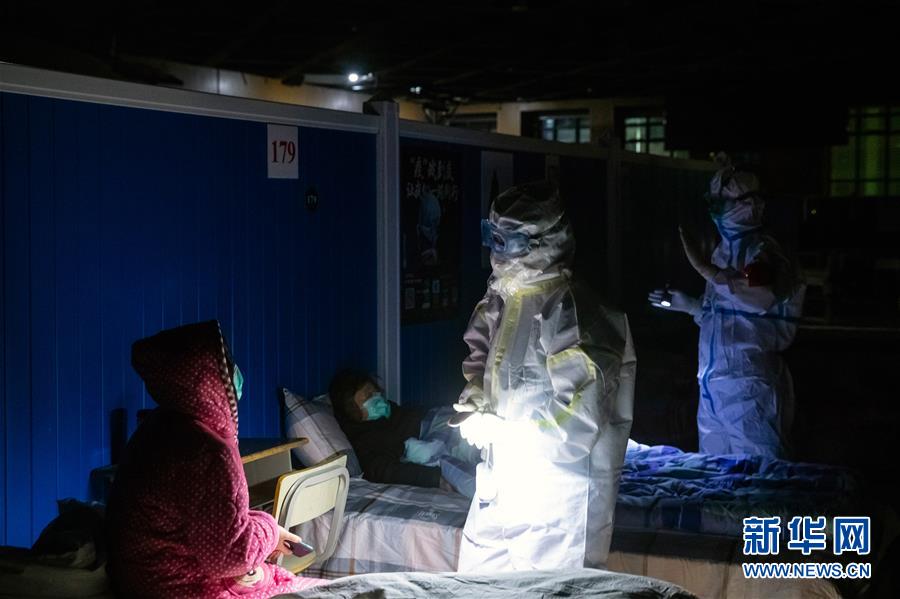 3월 9일 저녁 우한시 훙산체육관의 우창팡창병원에서 장시 후베이 지원의료팀원인 후페이(왼쪽 두번째)와 양청(楊成·오른쪽 첫번째)가 소등 후 순찰을 돌고 있다. [사진 출처: 신화망]
