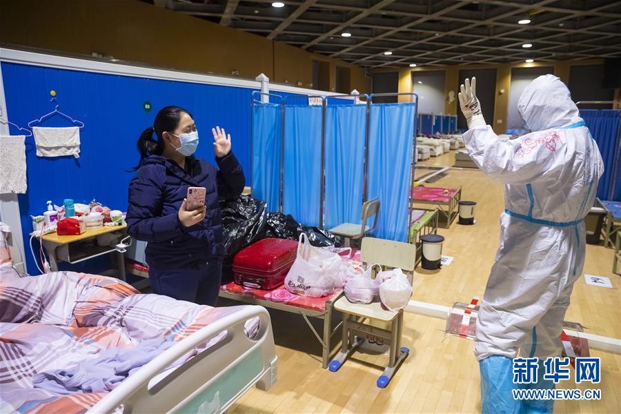 이날 밤 팡창병원에 남아 있는 코로나19 환자 잉 여사(왼쪽)와 상하이 푸단대학 부속 화산병원 의료진인 차오징레이가 손을 흔들며 작별 인사를 하고 있다. [사진 출처: 신화망]