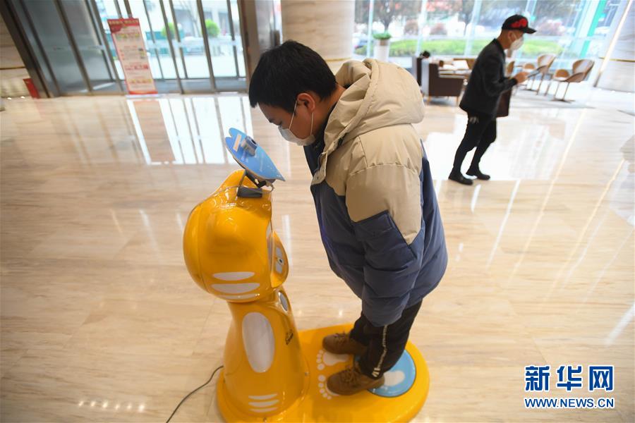 창사시 카이푸구 화촹(華創)국제광장빌딩에서 업무에 복귀한 직원이 아침 건강검진 방역 로봇으로 체온을 재고 있다. [3월 11일 촬영/사진 출처: 신화망]