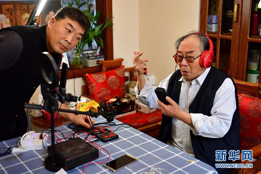 우중(오른쪽)이 라이브 방송 중 진극 공연 단락을 노래하고 있다. [3월 6일 촬영/사진 출처: 신화망]