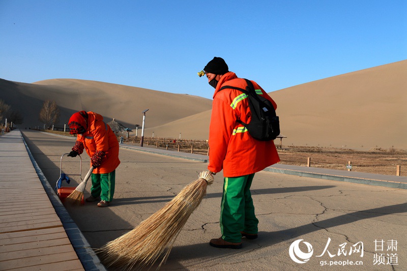 환경미화원이 둔황시 밍사산 웨야취안 관광지에서 청소를 하고 있다. [사진 출처: 인민망]