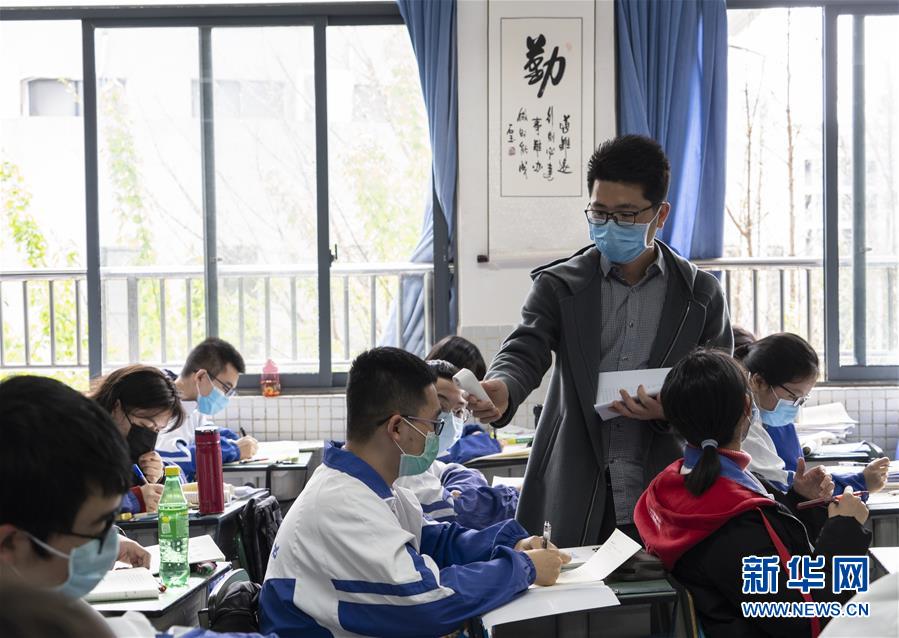 쓰촨성 청두(成都)시 쓰촨대학 부속고등학교 교사가 학생들의 체온을 재고 있다. [4월 1일 촬영/사진 출처: 신화망]