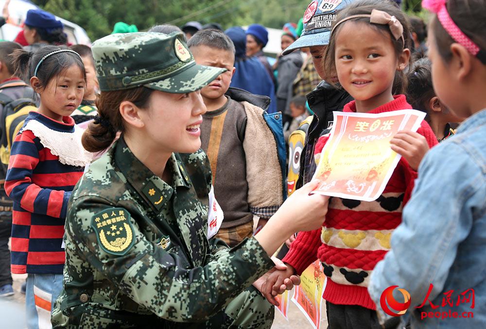 무장경찰 쓰촨총대 병사가 량산주 자오줸현 쒀쒀라다촌의 아이들과 함께 국제아동절을 맞았다. [사진 출처: 인민망]
