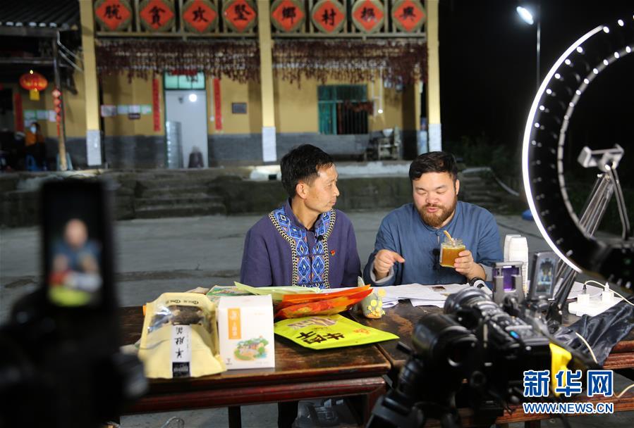 ‘털보 아저씨’(오른쪽)가 지난 15일 스주현 특산품인 꿀을 소개하고 있다. [사진 출처: 신화망]