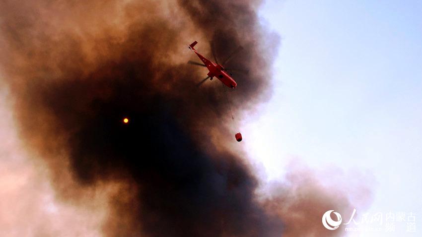 헬기로 물 탱크를 떨어뜨려 화재를 진압하고 있다. [사진 출처: 인민망]