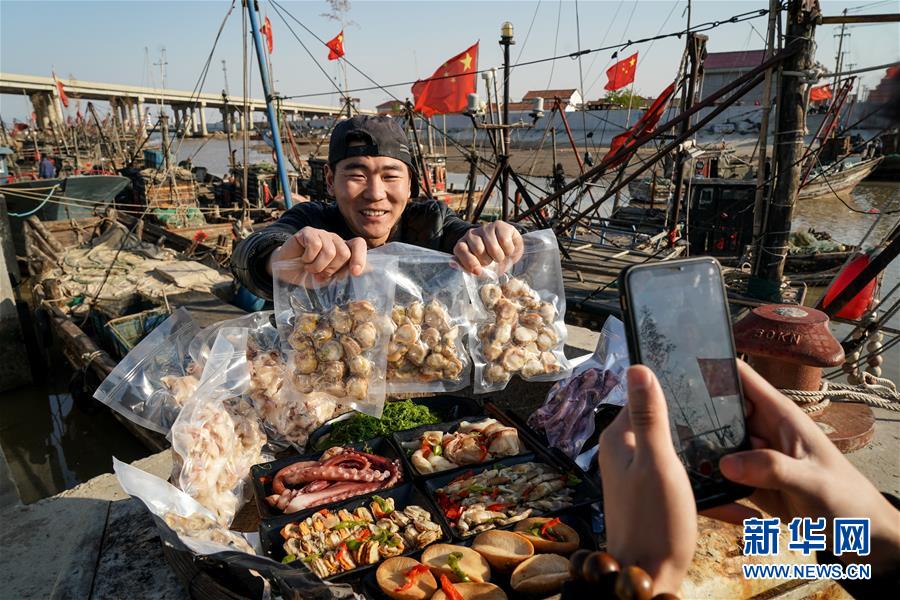 31세 구쥔하오(顧峻豪·왼쪽)가 주펑커우 어항에서 해산물 판매 쇼트 클립을 촬영하고 있다. 작년 9월부터 인터넷 라이브 방송을 통해 해산물을 판매하고 있으며 현재 구독자는 12만 명이다. [4월 22일 촬영/사진 출처: 신화망]