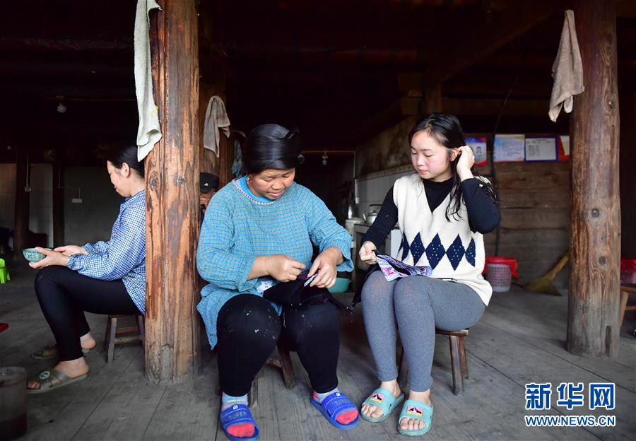 량멍샹과 그녀의 어머니가 묘족 옷에 수를 놓고 있다. [4월 15일 촬영/사진 출처: 신화망]