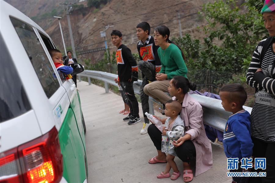 쓰촨성 자오줴현 아투례얼촌의 1차 빈곤가정 26가구는 자오줴현 빈곤구제 이주 집중 지역의 새집으로 가는 차 안에서 다른 주민들과 작별 인사를 하고 있다.  [5월 12일 촬영/사진 출처: 신화망]