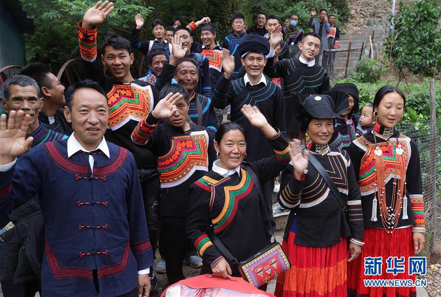 쓰촨성 자오줴현 아투례얼촌의 빈곤가정 26가구가 1차로 새집으로 이주했다. 일부 주민이 산 아래 도로에서 기념 촬영을 하고 있다. [5월 12일 촬영/사진 출처: 신화망]