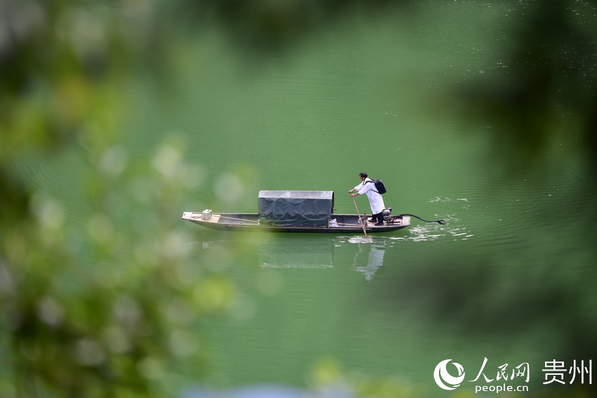 시골 의사 룽광칭이 5월 27일 나룻배를 저어 구이저우성 첸둥난 묘족·동족자치주 단자이현 파이댜오진 솽야오촌의 강을 건너 왕진을 가고 있다. [드론 촬영/사진 출처: 인민망]