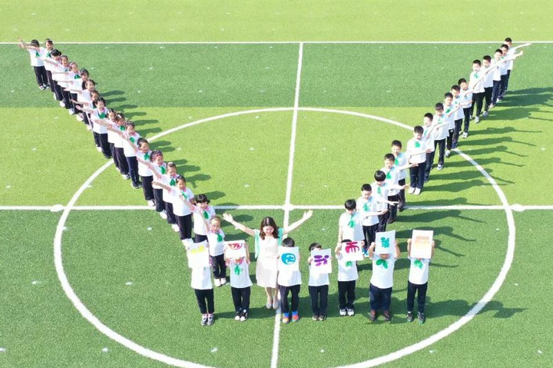 충밍(崇明)구 동문(東門)초등학교 선생님과 학생들이 한 쌍의 날개 모양을 만들어 날개짓을 하고 있다. [사진 출처: 상하이 교육 위챗 공식계정]