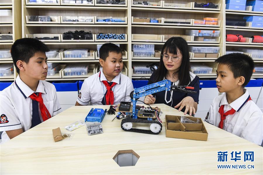 광시 싱예현 청시초등학교 교사(오른쪽 두 번째)가 학생에게 기계 모형에 대해 설명하고 있다. [5월 29일 촬영/사진 출처: 신화망]