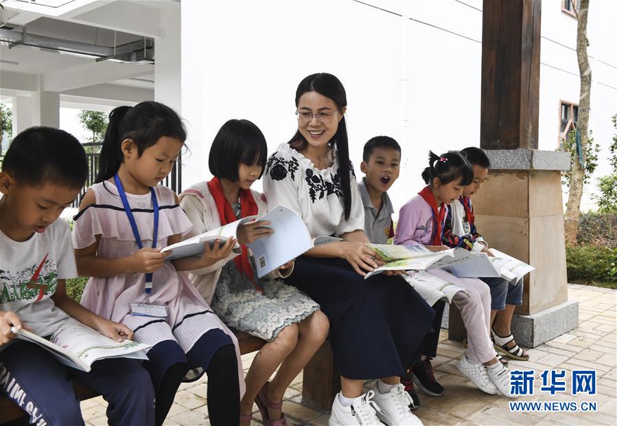 광둥의 교육지원 교사 궈이빙(郭一冰)이 여가 시간에 광시 룽안현 웨구이(粤桂)초등학교 학생들과 함께 책을 읽고 있다. [2019년 10월 16일 촬영/사진 출처: 신화망]