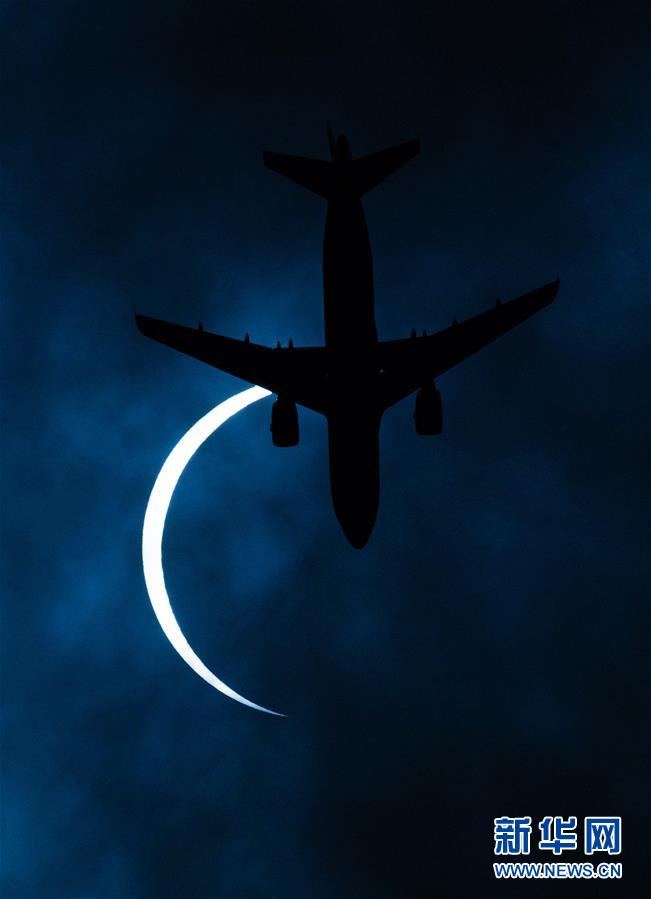라싸 상공에서 항공기 한 대가 일식이 나타난 태양을 지나가고 있다. [6월 21일 촬영/사진 출처: 신화망]