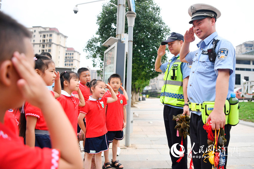아이들이 자신이 만든 쭝쯔와 향낭을 경찰에게 선물하자 경찰은 아이들에게 감사를 표했다. [사진 출처: 인민망]