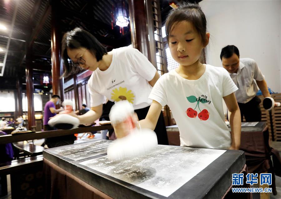 6월 27일 한 어린이가 가족과 함께 장쑤(江蘇) 쑤저우(蘇州) 비각박물관에서 탁본 공예를 체험하고 있다. 단오 기간 사람들은 아이와 함께 연휴를 즐겼다. [사진 출처: 신화망/촬영: 항싱웨이(杭興微)]