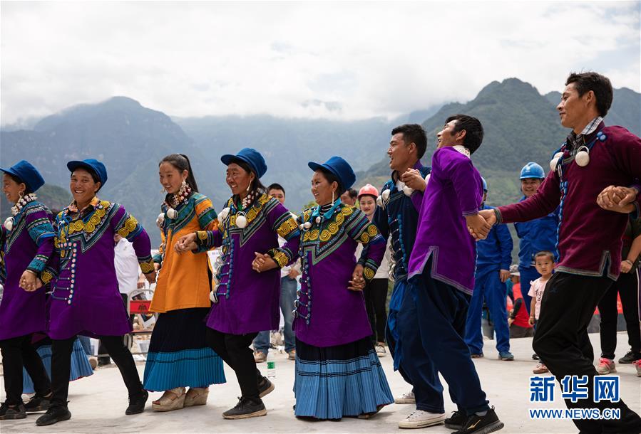6월 29일 아부뤄하촌 주민이 이족 전통 차림으로 노래를 부르고 춤을 추며 마을 도로 개통을 축하하고 있다. [사진 출처: 신화망]