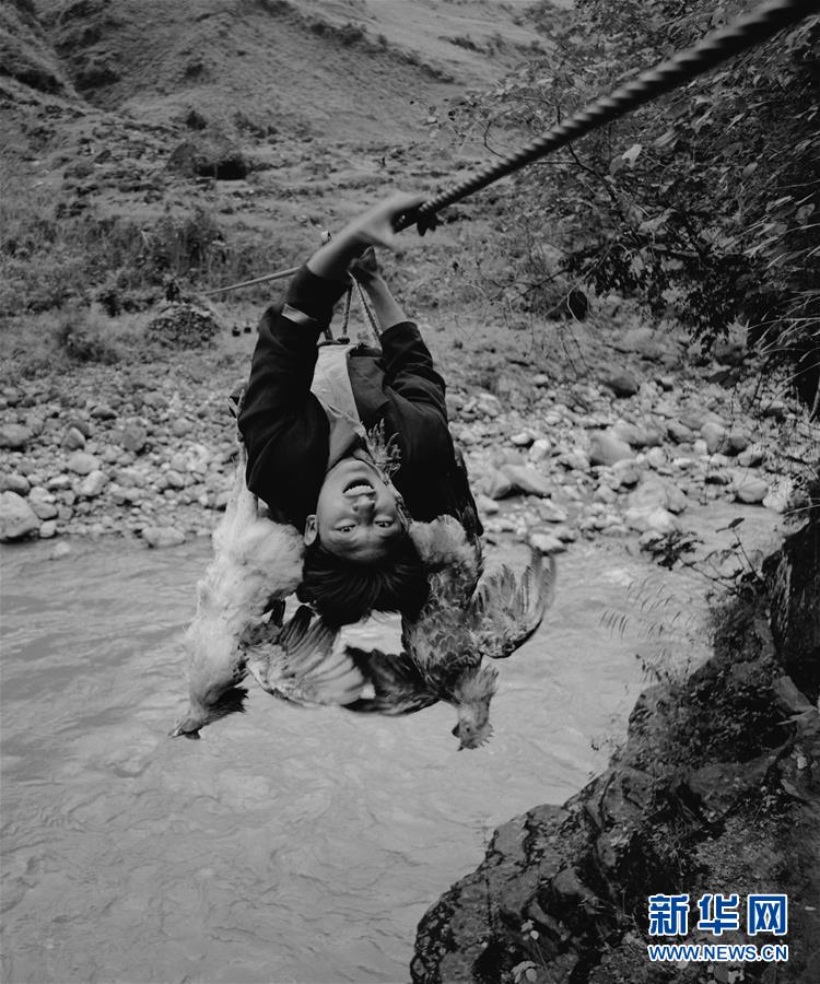 아다써구이(阿達色貴)가 아부뤄하촌에서 케이블로 시시(西溪)강을 건너고 있다. [2006년 3월 21일 촬영: 린창(林强)/사진 출처: 신화망]