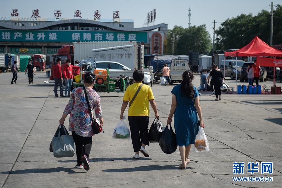 베이징 신파디 시장에서 격리가 해제된 사람이 생활용품을 들고 시장 주차장으로 차를 가지러 가고 있다. [사진 출처: 인민망]