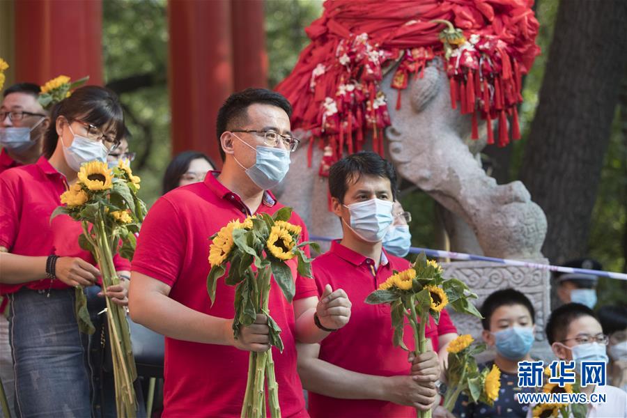 헤이룽장(黑龍江)성 하얼빈(哈爾濱)시 제3고등학교 고사장에서 선생님들이 해바라기를 들고 학생들을 맞이하고 있다.  