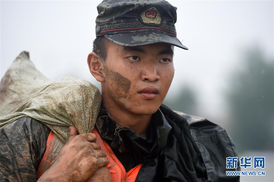 지난 18일 안후이성 허현 황바촌의 스바강댐에서 무장경찰 안후이총대 마안산지대 병사가 모래포대를 운반하고 있다. [사진 출처: 신화망]