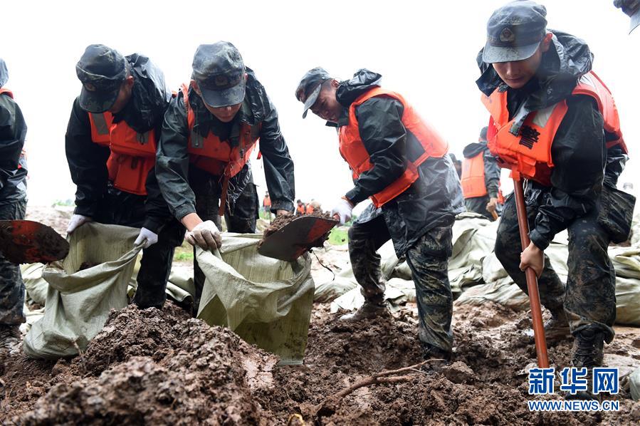 지난 18일 안후이성 허현 황바촌의 스바강댐에서 무장경찰 안후이총대 마안산지대 병사가 모래포대를 채우고 있다. [사진 출처: 신화망]