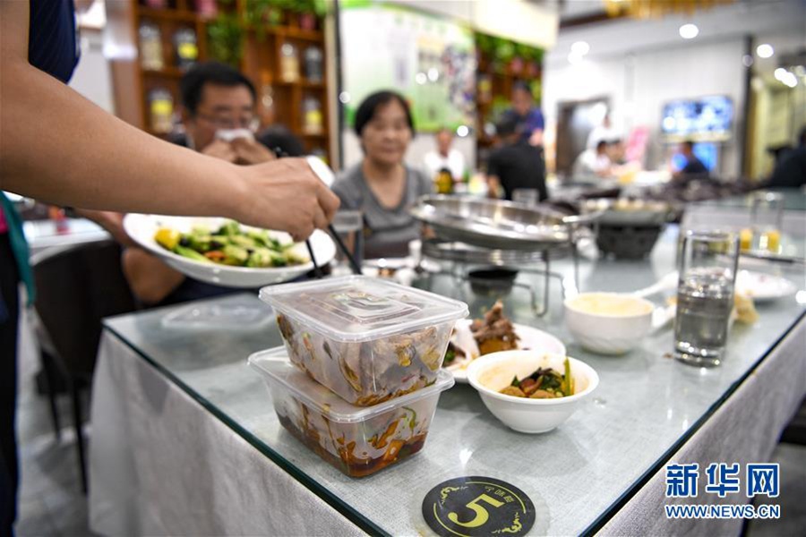 손님이 식사를 마치자 직원이 남은 음식을 포장하는 서비스를 제공하고 있다. [8월 15일 촬영/사진 출처: 신화사]