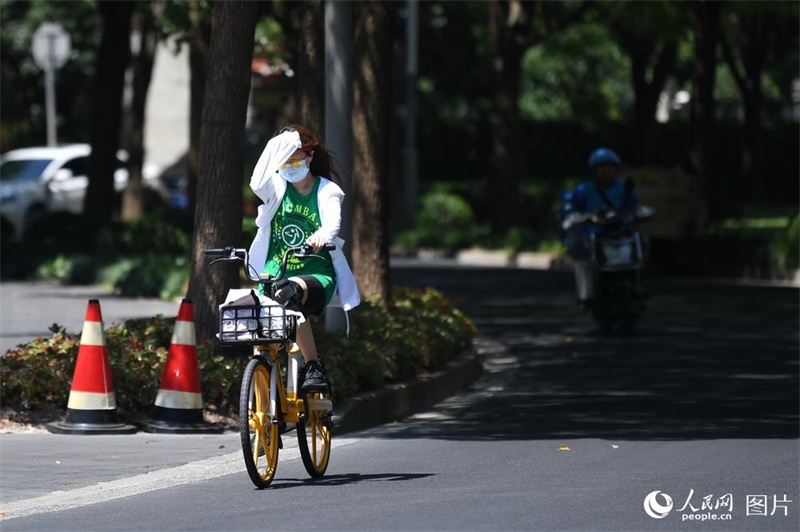 자전거를 탄 한 시민이 소매로 햇빛을 가리며 간다. [8월 20일 촬영/사진 출처: 인민망]