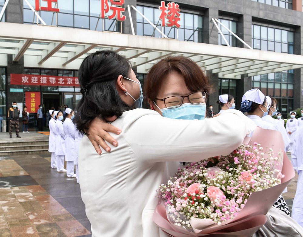 지난 23일 베이징중의병원의 후베이 지원 의료팀원 관리(關麗·오른쪽)이 우한셰허병원 서원을 재방문해 이비인후과 수간호사 후쥐안쥐안(胡娟娟)과 포옹하고 있다. [사진 출처: 인민망]