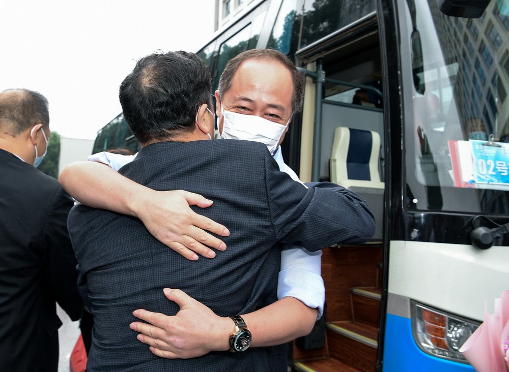 지난 23일 베이징안전(安貞)병원에서 온 후베이 지원 의료팀 팀장(오른쪽 첫 번째)이 막 버스에서 내려 우한셰허병원 당위원회 부서기 왕훙보(汪宏波) 교수와 포옹하고 있다. [사진 출처: 인민망] 