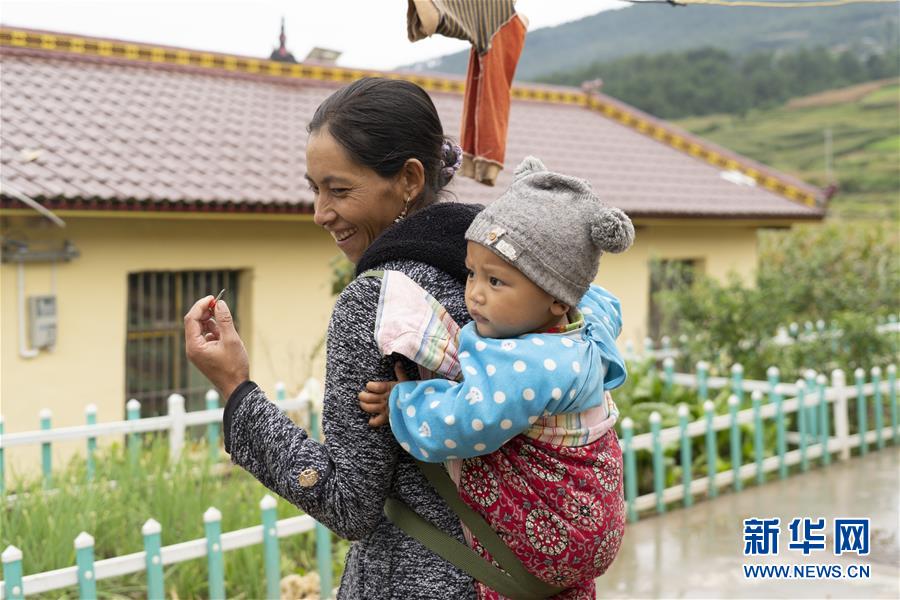 9월 26일 쓰촨 시더현 나이퉈신촌, 이족 부녀자가 아이와 함께 즐거운 때를 보낸다. [사진 출처: 신화망]
