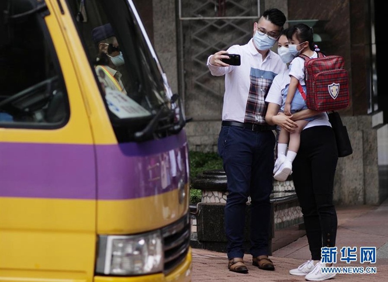 홍콩 훙칸(红磡), 학부모들이 스쿨버스를 타려는 학생들과 기념사진을 찍는다. [사진 출처: 신화망]