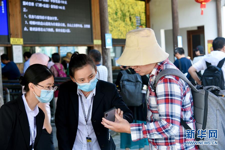 장시(江西) 우위안(婺源) 황링(篁嶺) 관광지 자원봉사자가 관광객의 문의에 답하고 있다. [10월 1일 촬영/사진 출처: 신화망]