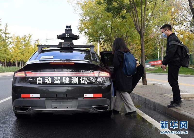 베이징 시민이 하이뎬구에서 바이두 자율주행 택시 지정역에서 차에 탑승한다. [사진 출처: 신화망]