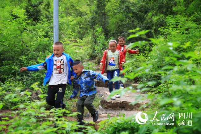량산 자오줴현 ‘쉬안야촌’의 아이들이 산을 내려가고 있다. [사진 출처: 인민망]