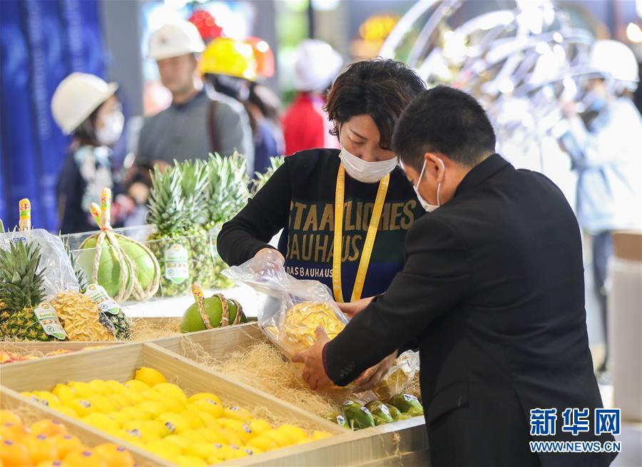 식품 및 농산물 전시관에서 참가 기업 직원들이 전시품을 진열하고 있다. [사진 출처: 신화망]