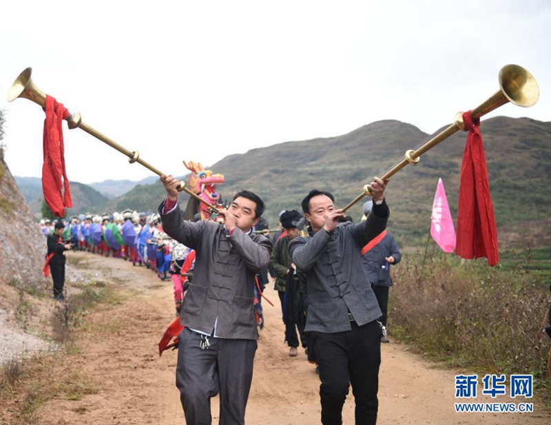 묘족 동포가 트롬본을 불며 축하하고 있다. [사진 출처: 신화사]