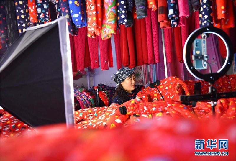지난 22일 산둥성 쯔보시 이위안현 둥리(東裏)진의 한 공방에서 농가 부녀자가 라이브 스트리밍을 통해 솜옷을 팔고 있다. [사진 출처: 신화사]
