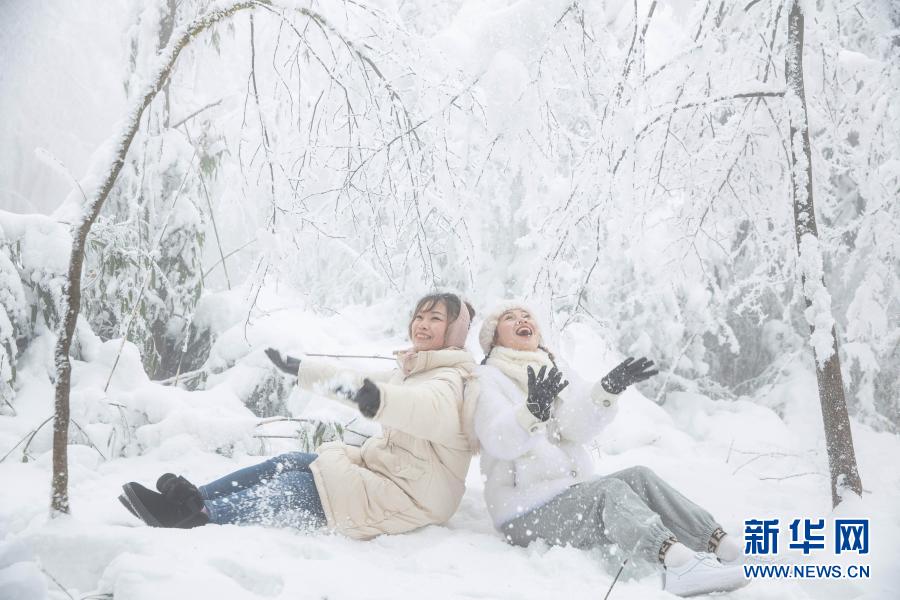 12월 12일, 관광객 두 명이 어메이산 눈 속에서 장난치고 있다. [사진 출처: 신화망]