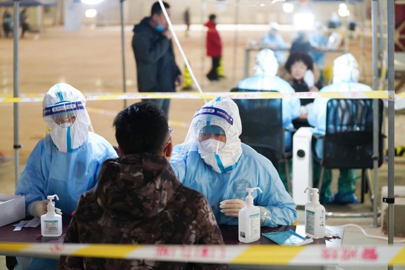 지난 20일 베이징시 다싱구 팡거좡진 핵산검사소에서 의료진이 핵산검사 중인 사람들의 시료를 채취하고 있다. [사진 출처: 신화망]