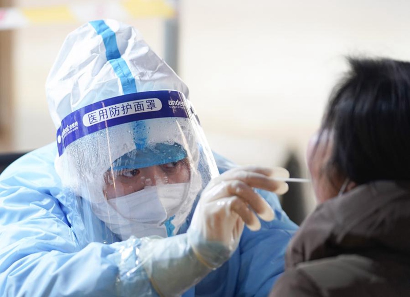 지난 20일 베이징시 다싱구 팡거좡진 핵산검사소에서 의료진이 핵산검사 중인 사람들의 시료를 채취하고 있다. [사진 출처: 신화망]