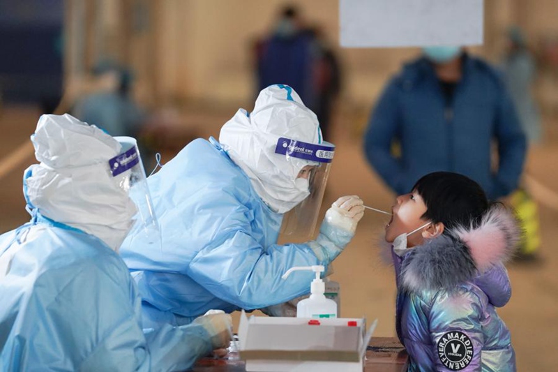 지난 20일 베이징시 다싱구 팡거좡진 핵산검사소에서 직원이 어린아이에게 핵산검사를 하고 있다. [사진 출처: 신화망]