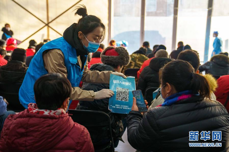 베이징시 차오양규획예술관의 백신 접종소, 자원봉사자가 관찰구역에서 큐알 코드를 들고 접종자의 등록을 돕고 있다. [1월 26일 촬영/사진 출처: 신화망]