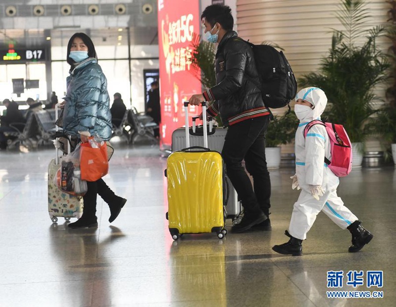 난징 남역, ‘완전 무장’한 어린이가 부모님을 따라 열차에 탑승하러 가고 있다. [사진 출처: 신화망]
