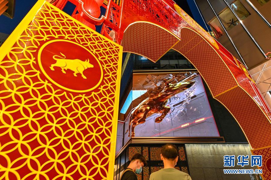 지난 10일 말레이시아 콸라룸푸르에서 사람들이 대형 모니터로 3D ‘진뉴(金牛ㆍ황금 소)’ 영상을 보았다. 춘절을 맞아 콸라룸푸르의 한 상점 대형 모니터에는 3D효과의 ‘진뉴’ 영상으로 음력 새해를 축복하고 사람들이 손잡고 방역에 힘써 코로나19에서 승리하기를 격려했다. (사진 출처: 신화망)