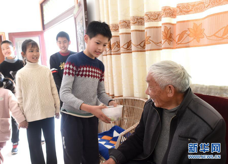 펑위안촌의 어린이가 익힌 탕위안을 마을 노인에게 드리고 있다. [사진 출처: 신화망]