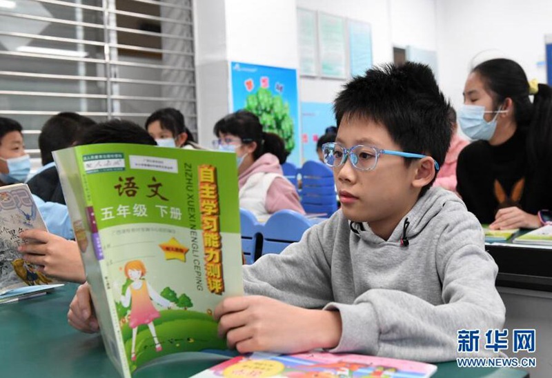 2월 27일, 한 학생이 받은 새 책을 읽고 있다. [사진 출처: 신화망]